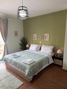 a bedroom with a large bed with two towels on it at Down Town Apartments in Kavála