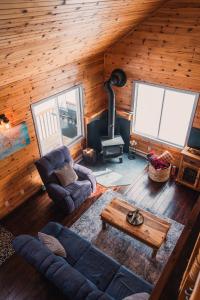 a living room with a couch and a table in a cabin at Repère de la Rivière - Bord de l'eau- Activités nautiques in Saint-Alexis-des-Monts +29 photos
