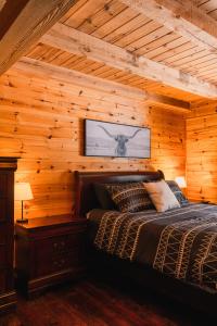 a bedroom with a bed in a wooden wall at Repère de la Rivière - Bord de l'eau- Activités nautiques in Saint-Alexis-des-Monts