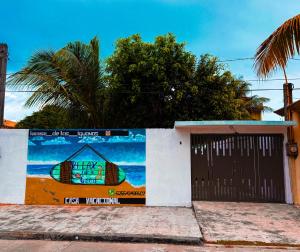 a building with a door with a surfboard painted on it at Casa de las Iguanas Tecolutla in Tecolutla