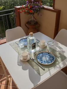 a table with two plates and a bottle on it at Ravè in Praia a Mare
