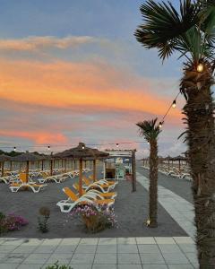 a group of chairs and umbrellas on a beach at Bahr DELUXE App & Suite in Ulcinj