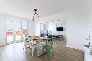 a dining room and living room with a table and chairs at Nouveau - Horizons - Vue mer in Saint-Nazaire