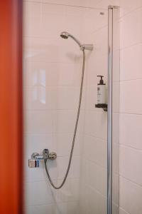 a shower with a shower head in a bathroom at Hotel Restauracja Jaś Wędrowniczek in Rymanów +96 photos