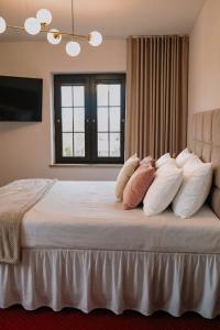 a bedroom with a large bed with white pillows at Hotel Restauracja Jaś Wędrowniczek in Rymanów