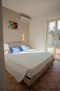 a bedroom with a large bed with blue pillows at Ravè in Praia a Mare