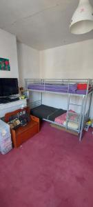 a room with two bunk beds and a pink carpet at Maison de ville in Rouen