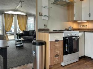 a kitchen with a stove and a living room at The Meadow - Uk51411 in Brechin +6 photos