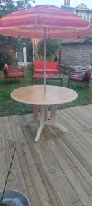 a table with an umbrella on a wooden deck at Maison de ville in Rouen +10 photos