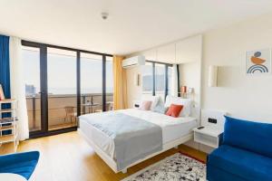 a bedroom with a white bed and a blue chair at Orbi HighView Panoram Hotel in Batumi