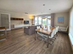a dining room and living room with a table and chairs at Duinhof IX E204 in Cadzand