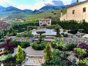 a garden in front of a building with mountains in the background at Villa Basilicata in Pedale
