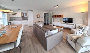 a living room and dining room with a couch and a table at Duinhof IX E204 in Cadzand +5 photos