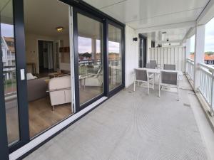 a balcony with glass doors and a table and chairs at Duinhof IX E204 in Cadzand