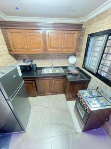a kitchen with wooden cabinets and a stainless steel refrigerator at Egel appartement in Yaoundé +9 photos