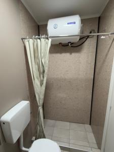 a bathroom with a toilet and a air conditioner at Down Town Apartments in Kavála