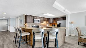 a kitchen with a bar with stools in it at Phoenix X 514 condo in Orange Beach