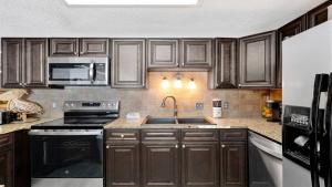 a kitchen with wooden cabinets and a sink at Phoenix X 514 condo in Orange Beach