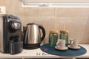 a kitchen counter with a coffee maker and two cups at Il Gioiello di Frieda - in centro a Muggia in Muggia