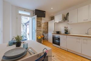 a kitchen with white cabinets and a counter top at Il Gioiello di Frieda - in centro a Muggia in Muggia