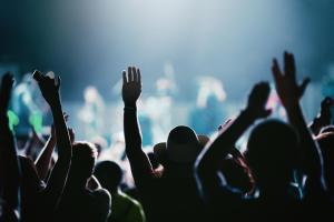 a crowd of people with their arms up at a concert at Nine Yards Bell Tents - Lytham in Lytham St Annes