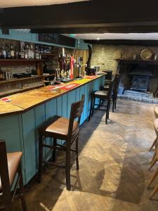 a bar with a row of chairs in a restaurant at The Hayloft in Oaksey