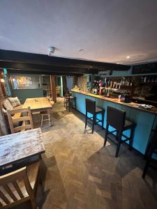 a restaurant with tables and chairs and a bar at The Hayloft in Oaksey
