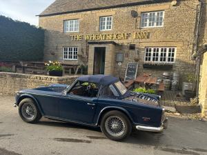 a blue car parked in front of a building at The Hayloft in Oaksey