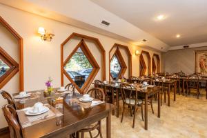 a dining room with wooden tables and chairs at Hotel Chateau in Campos do Jordão