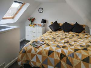a bedroom with a bed with a colorful comforter at Puffin Cottage in Fraserburgh +25 photos