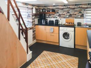 a kitchen with a washer and dryer in a room at Puffin Cottage in Fraserburgh