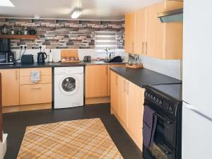 a kitchen with a washer and dryer at Puffin Cottage in Fraserburgh