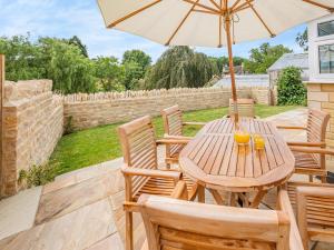 a wooden table and chairs with an umbrella at The Mill Lodge in Malmesbury