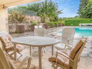 a patio with a table and chairs next to a pool at The Mill Lodge in Malmesbury +14 photos
