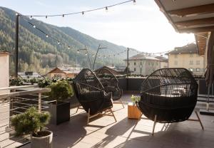 two chairs on a balcony with a view of a mountain at Casa Orso Elio - Si Mezzana Home in Mezzana