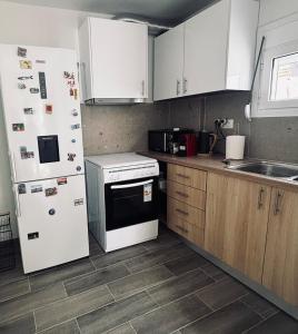 a kitchen with white appliances and wooden cabinets at Nára house 3 in Spata