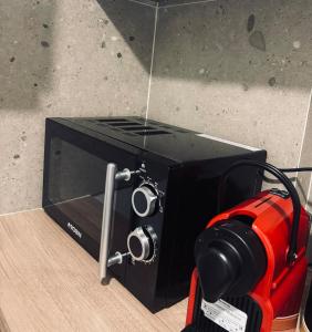 a black microwave with a camera in front of it at Nára house 3 in Spata +9 photos