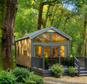 a small cabin in the woods with trees at Aberdunant Hall Holiday Park, Snowdonia in Porthmadog