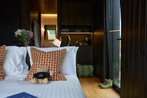 a teddy bear sitting on a bed with pillows at Mad Swans in The Mendips in Farrington Gurney +31 photos