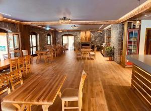 a large room with wooden tables and chairs at Golden Villa in Theth