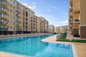 a swimming pool in front of some apartment buildings at Sapphire Suite #pool&parking #Cosmopolis in Ştefăneştii de Sus +1 photo