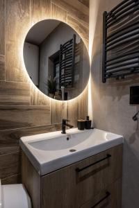 a bathroom with a white sink and a mirror at Zacisze Anioła in Łobozew +26 photos