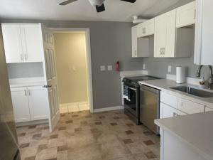 a kitchen with white cabinets and a stove top oven at Bungalow Bleu in St. Petersburg