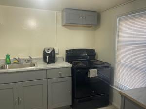 a kitchen with a black stove and a sink at Bungalow Bleu in St. Petersburg