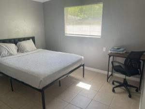 a bedroom with a bed and a desk and a chair at Bungalow Bleu in St. Petersburg