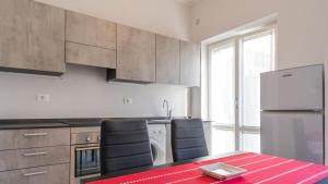 a kitchen with a red table and a refrigerator at Suite Alarcon - Goelba in Porto Azzurro +7 photos