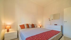 a bedroom with a bed with a red blanket at Suite Alarcon - Goelba in Porto Azzurro