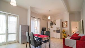 a kitchen and living room with a table and a couch at Suite Alarcon - Goelba in Porto Azzurro