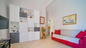 a living room with a red couch and a tv at Suite Alarcon - Goelba in Porto Azzurro