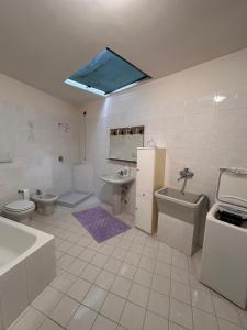 a bathroom with a sink and a toilet and a bath tub at Casa vacanze Orchidea in Treviolo